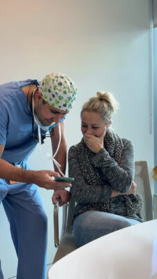 Dr. Tahiri showing a patient photos on his phone during a consultation