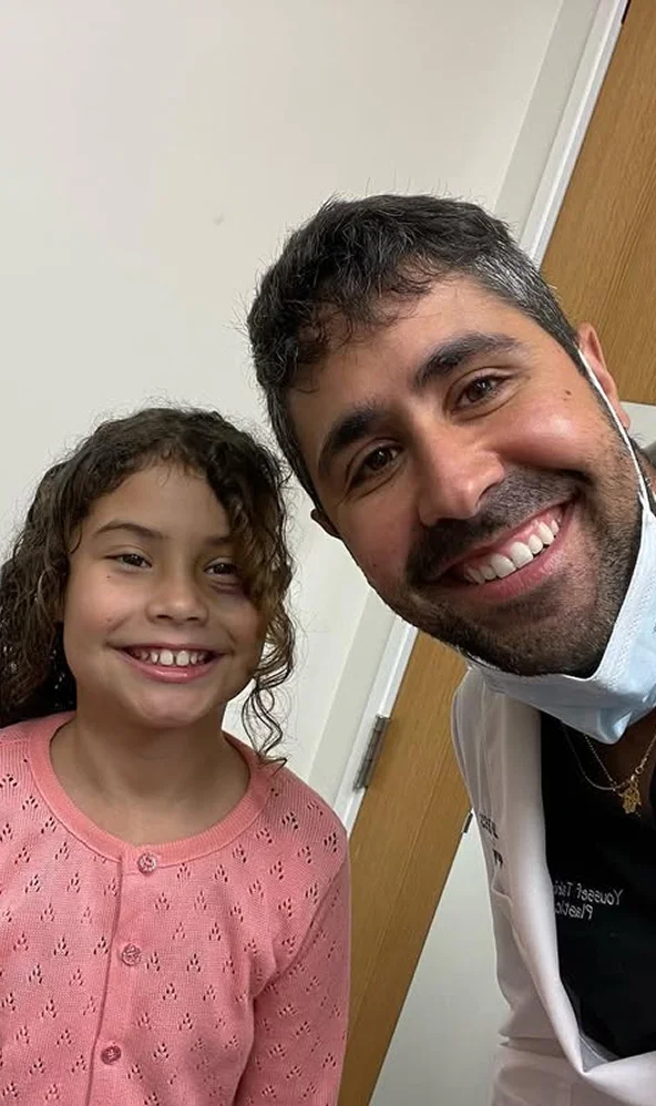 Dr. Tahiri smiling with a young patient